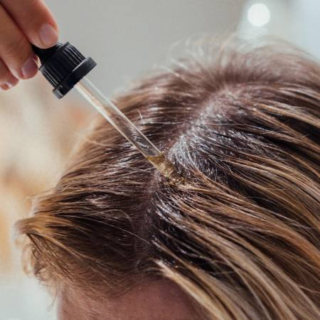 Application de la lotion anti-chute sur le cuir chevelu